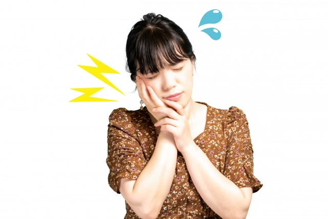 頬を押さえて痛がる女性