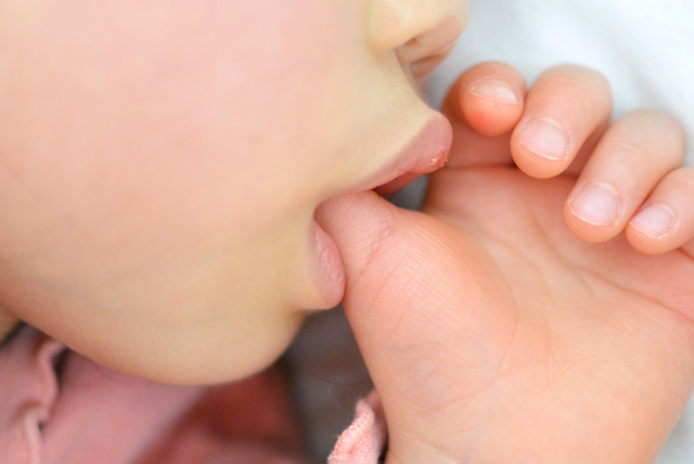 指しゃぶりしている子どもの口元
